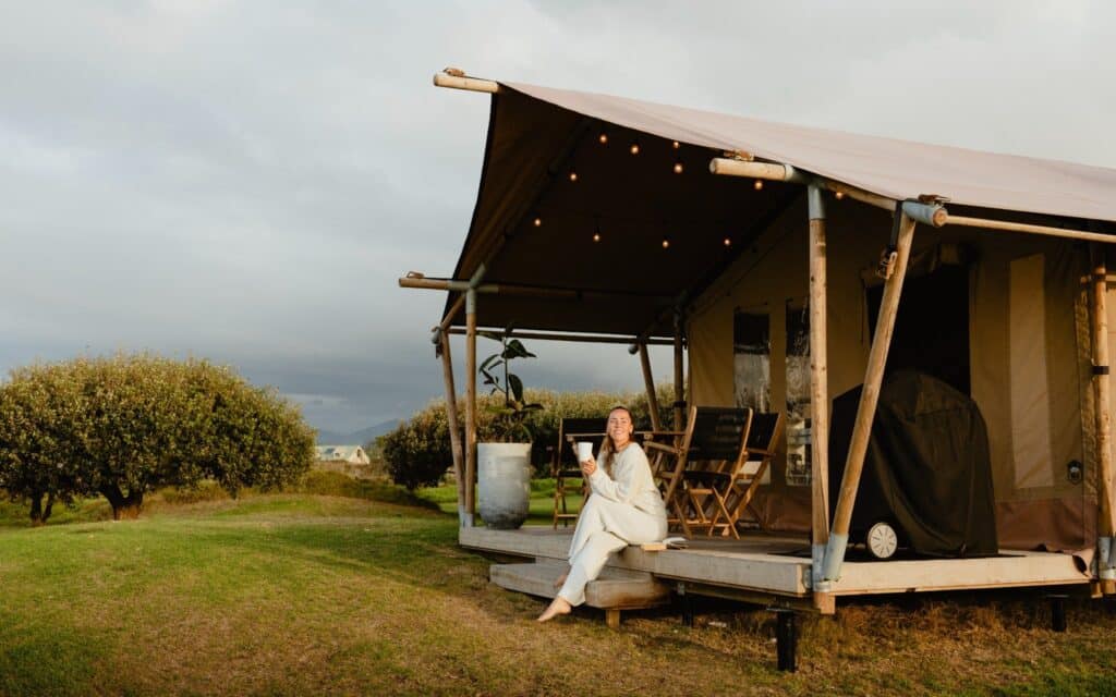 Woman sitting on the balcony of a glamping tent